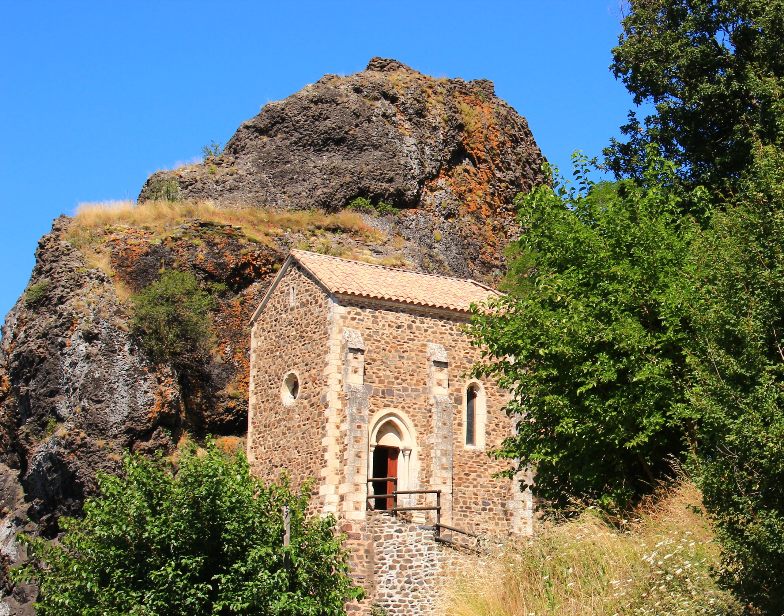 Chapelle de la Roche Chérie lovée contre son neck volcanique à St Pons